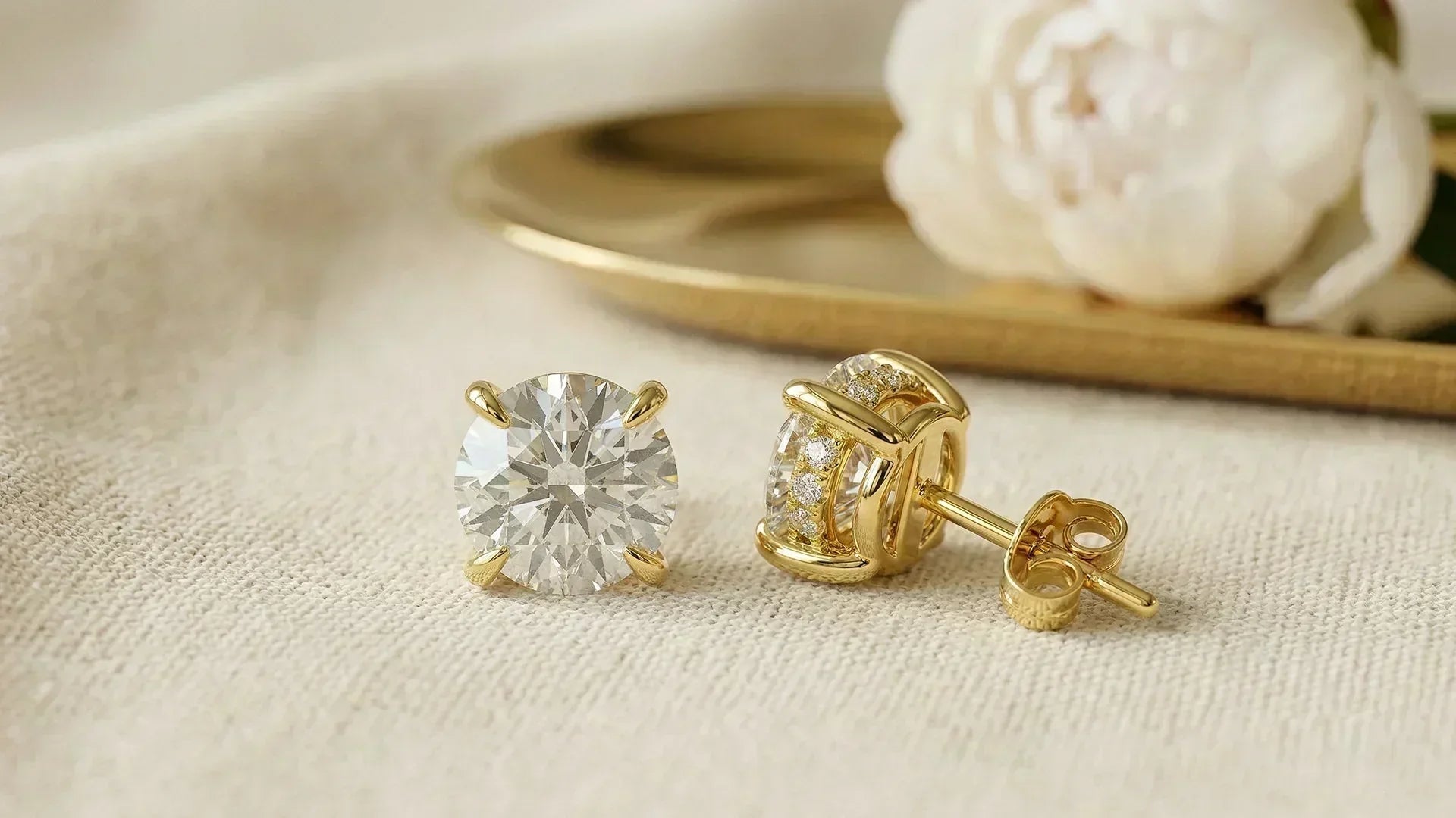 Round hidden halo lab-grown diamond studs on cream linen 