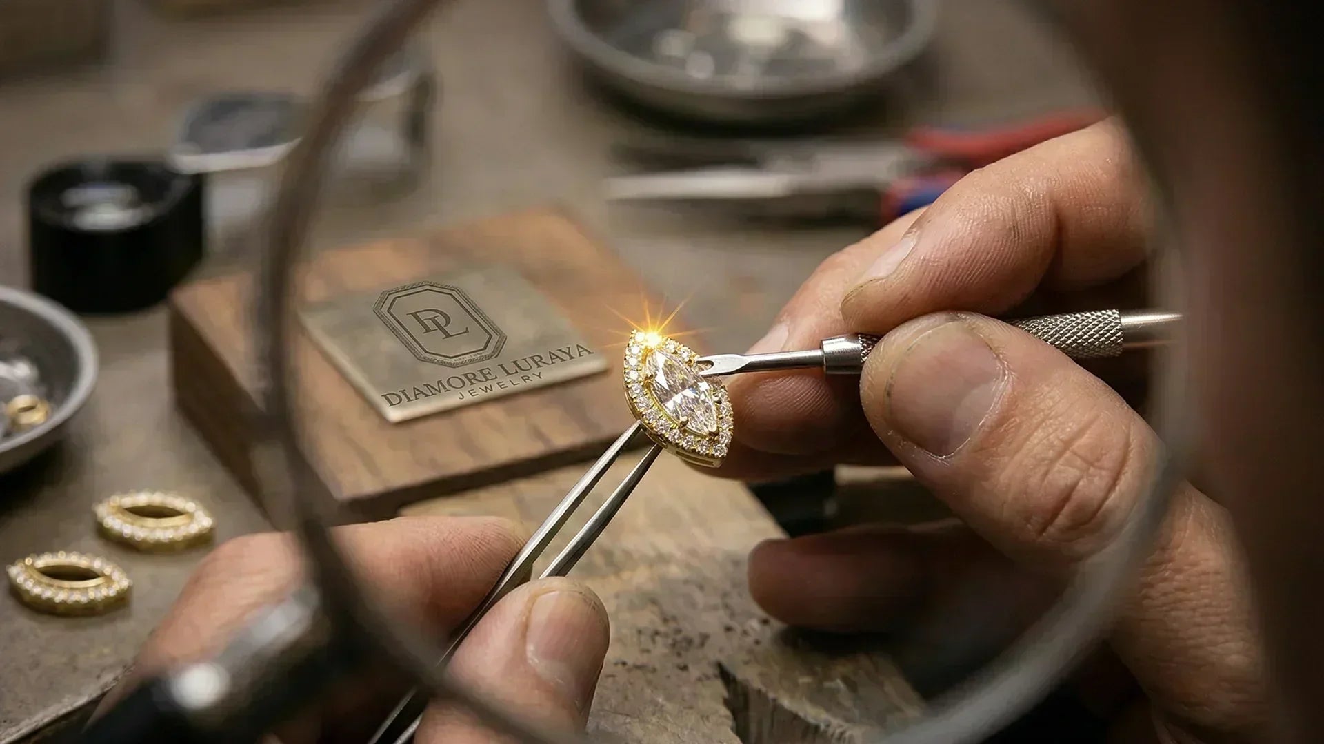 Handcrafted diamond halo stud earrings on a jeweler's workbench
