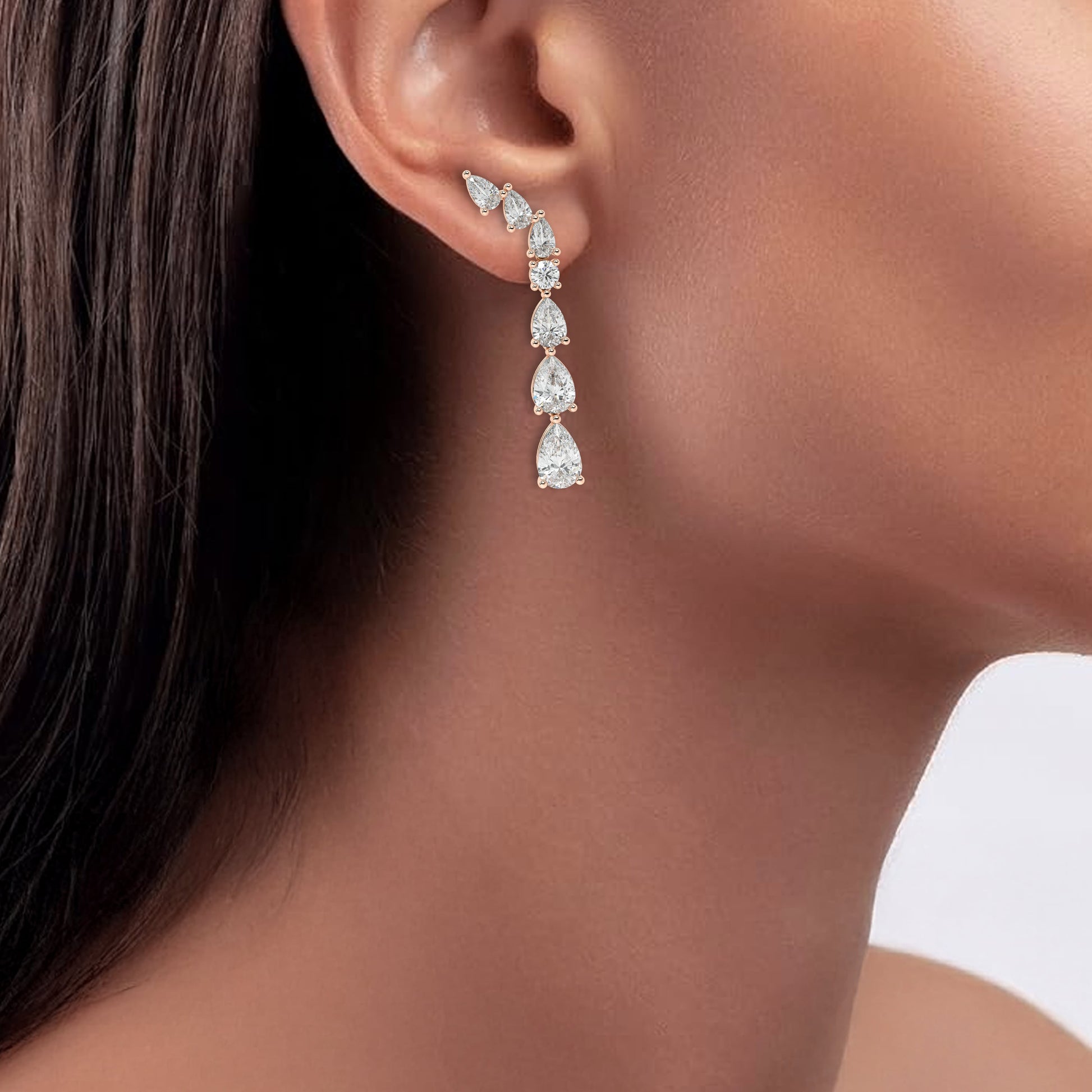 Rose gold diamond climber earrings worn on ear close-up, elegant pear shaped vine cascade on model, trendy rose gold lab diamond jewelry