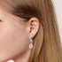 Model wearing rose gold lab-grown diamond solitaire stud earrings on ear, side profile, dazzling single round diamond, feminine luxury pieces