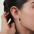 Model wearing rose gold lab-grown diamond cascading floral stud earrings on ear, side profile, dazzling marquise and pear Pavé design, feminine diamond pieces