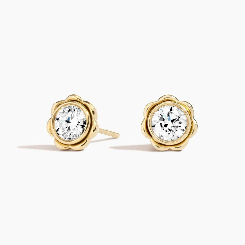 Fleur bezel stud earrings featuring a round lab-grown diamond in a sculpted floral yellow gold setting with screw back closures.