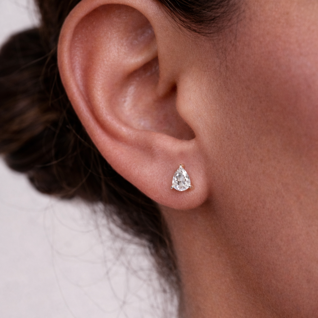 Pear hidden halo earrings shown in lifestyle setting