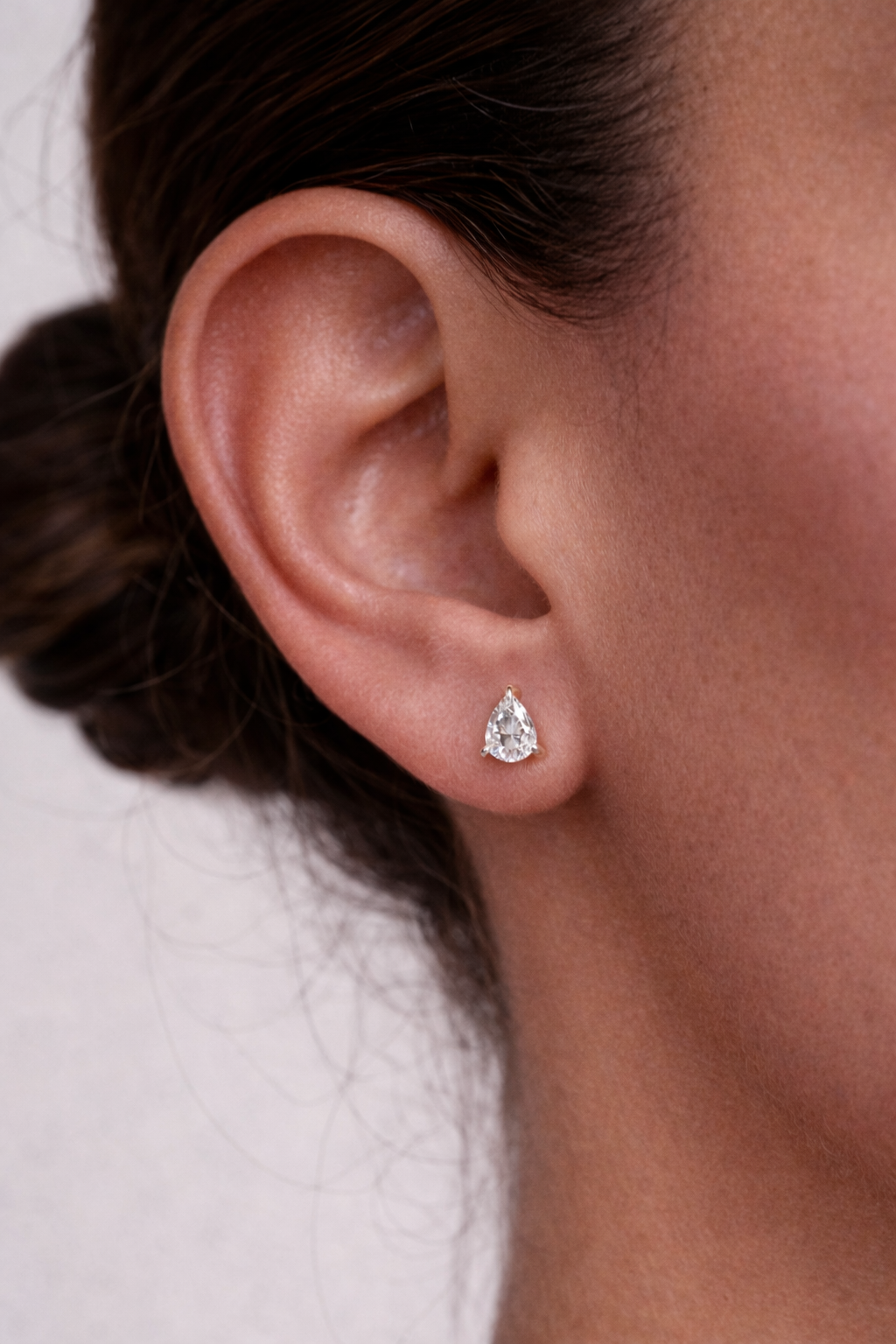 Pear hidden halo earrings shown in lifestyle setting