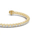 Close-up of U-shaped prongs on a yellow gold tennis bracelet